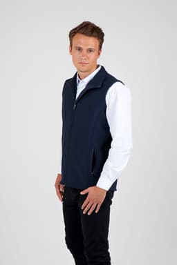 A man wearing a navy soft shell vest with a zip and side pockets, set against a plain background.