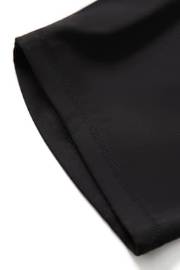 A close-up of black women's high-rise full-length leggings, featuring a smooth fabric and neat stitching.