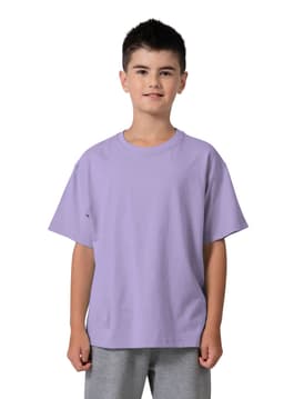 A regular fit kid's T-shirt in lavender, displayed on a young model. The shirt has a logo on the sleeve.