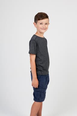 A child in a heather grey t-shirt stands sideways, wearing navy shorts, with a simple background.