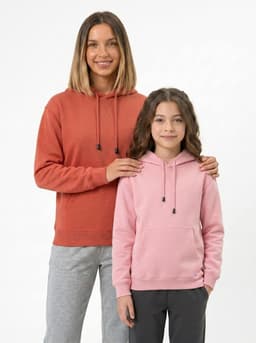 A woman and a girl wearing kangaroo pocket hoodies in rust and pink, with drawstrings and a casual fit.