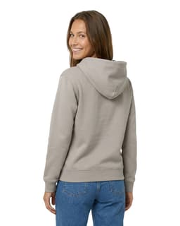 A woman wearing a light grey hoodie with a kangaroo pocket and a hood, facing away from the camera.