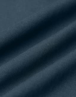 A close-up of dark blue fabric, featuring folds and a textured surface. The image has a subtle sheen.