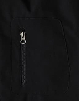 A black men's softshell jacket featuring a zipped pocket. The fabric appears smooth and high-tech. 