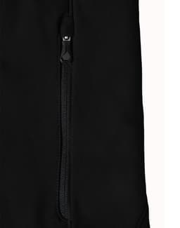 A close-up of a black softshell jacket featuring a zipped pocket and a branded logo.