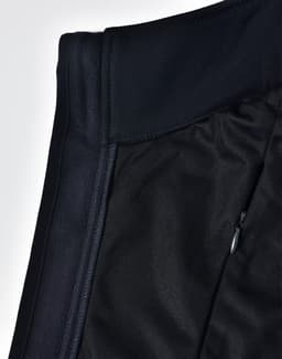 A close-up of a black ladies' softshell hi-tech vest showcasing its fabric textures and a zippered pocket.