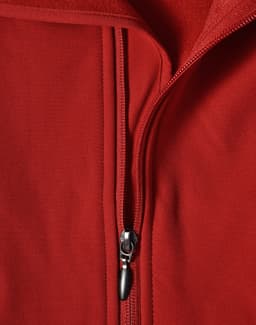 A red softshell vest with a zippered front and a fleece interior, featuring a logo.