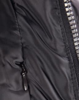 A close-up of a heavy quilted black puffer jacket featuring a zip and a side pocket. It has a logo on the front.