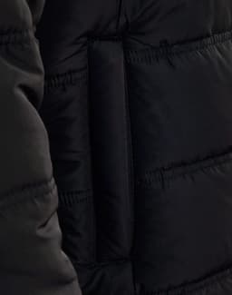 A close-up of a black heavy quilted jacket, highlighting the texture and stitching. The jacket features a brand logo.