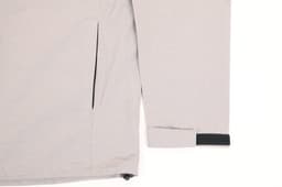 A light grey men's waterproof performance jacket featuring a zipped pocket and adjustable cuffs. The jacket includes branding.
