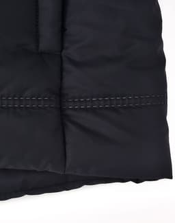 A close-up of a black seamless parka jacket, featuring a textured fabric and contrasting stitching details.