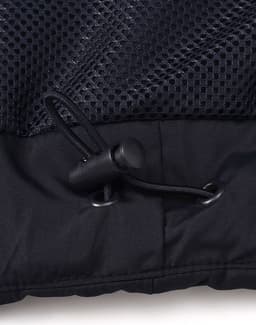 A close-up of a black unisex parka jacket featuring a mesh panel and adjustable drawcord at the hem.