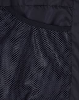 A close-up of the interior lining of a black sustainable parka jacket featuring a mesh texture.