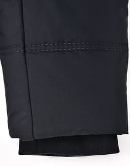 A close-up of a black seamless parka jacket sleeve, featuring stitching details and a knitted cuff.