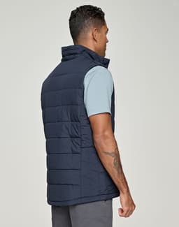 A men's sustainable insulated puffer vest in navy, featuring a 3D cut design, viewed from the back.