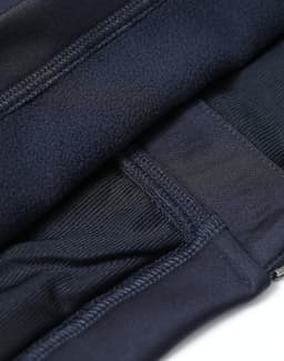 A close-up of a navy women's sustainable softshell corporate jacket, highlighting its stitching and fabric texture.
