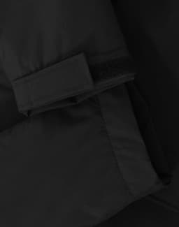 A close-up of a black unisex quilted waterproof jacket featuring a Velcro cuff and smooth fabric texture.