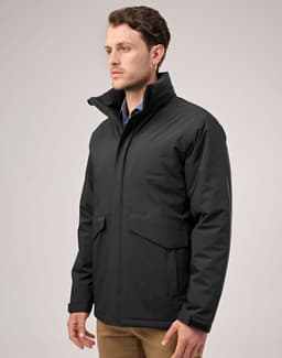 A black unisex quilted waterproof jacket with a high collar and side pockets displayed on a model.