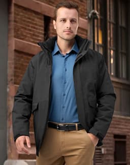 A unisex quilted waterproof jacket in black, featuring a hood and front pockets, worn by a model outdoors.