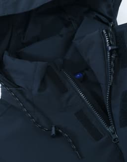 A unisex quilted waterproof jacket in navy, featuring zippers and adjustable toggles. Includes branding details.