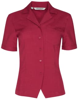 A short-sleeve overblouse in a rich burgundy colour with a collar and a single chest pocket. Features a logo.
