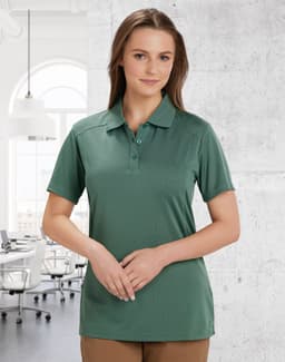 A green ladies' polo shirt featuring a collar and buttons, displayed in a bright office environment.