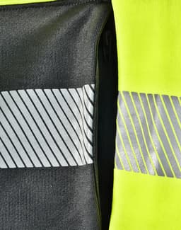 A bright yellow work jumper featuring reflective stripes and a zipper pocket in a contrasting dark grey fabric.