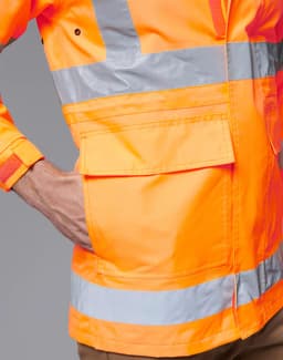 An orange safety jacket with reflective stripes and a pocket, designed for high visibility. Contains a logo.