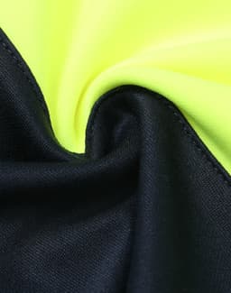 A close-up of a fabric featuring fluorescent yellow and navy blue sections, with a smooth texture and a logo.