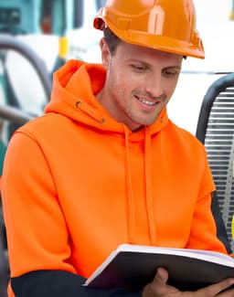 A bright orange and black water-resistant fleece hoodie with a hood, worn by a person in safety gear, reading a book.