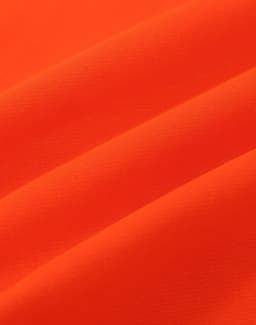An orange fabric with a smooth texture, featuring folds that highlight its soft appearance.