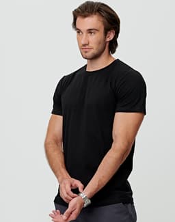 A black men's premium cotton tee displayed on a model, featuring short sleeves and a standard fit.
