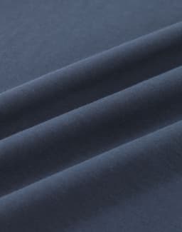 A close-up of dark navy blue cotton fabric, showcasing its smooth texture and folds.
