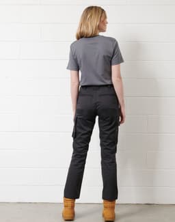 A model wearing a grey short-sleeve work T-shirt paired with black trousers and tan work boots.