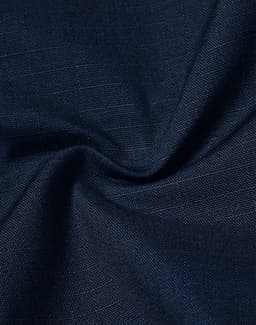 A close-up view of navy rip-stop poly/cotton fabric, showcasing its textured weave and stretch properties.