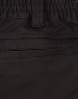 A close-up of black cotton stretch drill work shorts, featuring an elastic waistband and pockets.