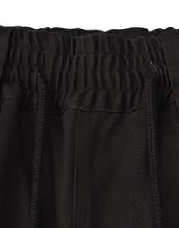 A close-up of the waistband of black unisex cotton stretch drill work shorts, featuring an elastic band and drawstring.