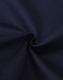 A close-up view of dark blue cotton fabric, showing its smooth texture and stretch quality.