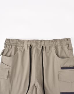 Unisex cotton stretch drill short work shorts in beige with an elastic waistband and multiple pockets.