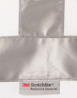 A reflective silver strip on a white fabric with a label for 3M Scotchlite reflective material.
