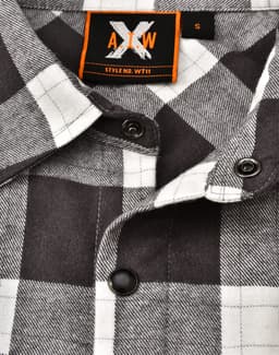 A black and white plaid unisex flannel button-up shirt featuring a collar and branded tag.