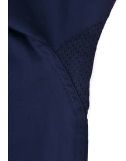 A close-up of a navy blue work shirt featuring a mesh panel for ventilation, with stitching details visible.