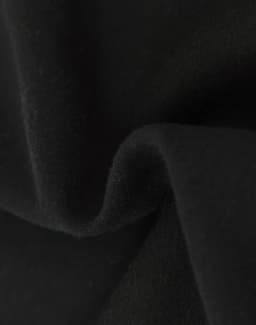 A close-up of soft, black fabric showcasing a textured surface, indicating a fleece material.