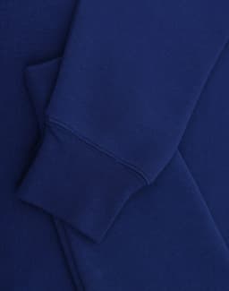 A blue crewfleece jumper featuring a close-up of the sleeve and cuff details. It has a small logo.