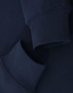 A navy crewneck sweatshirt featuring folded cuffs and a simple design, with a logo present.