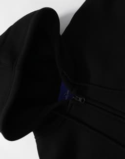 A black men's full-zip fleecy hoodie featuring a hood and a zipper, with a logo visible on the inside.