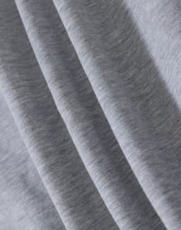 A close-up of light grey fabric, showcasing the soft texture of a fleecy material.