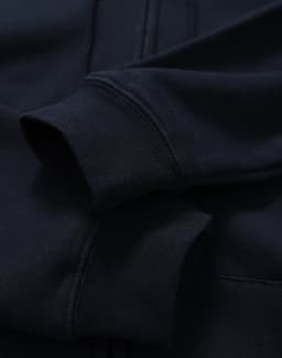 A men's full-zip fleecy hoodie in navy, featuring cuffed sleeves and a smooth fabric texture.