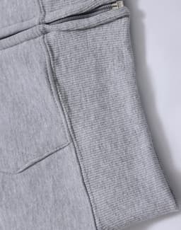 A grey fleecy hoodie featuring a full zip and ribbed cuff detail. It includes pockets and has a logo.