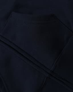 A close-up of a navy blue kid's full-zip fleecy hoodie featuring a kangaroo pocket and a logo.